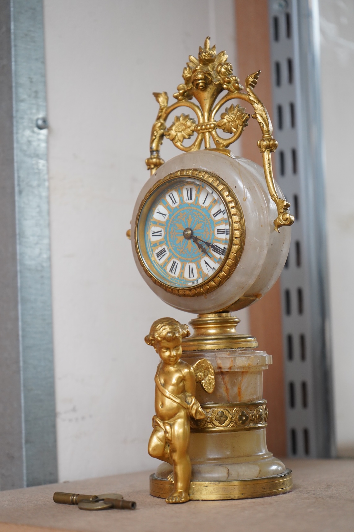 A late 19th century French ormolu and alabaster timepiece with painted dial and key, 24cm high
